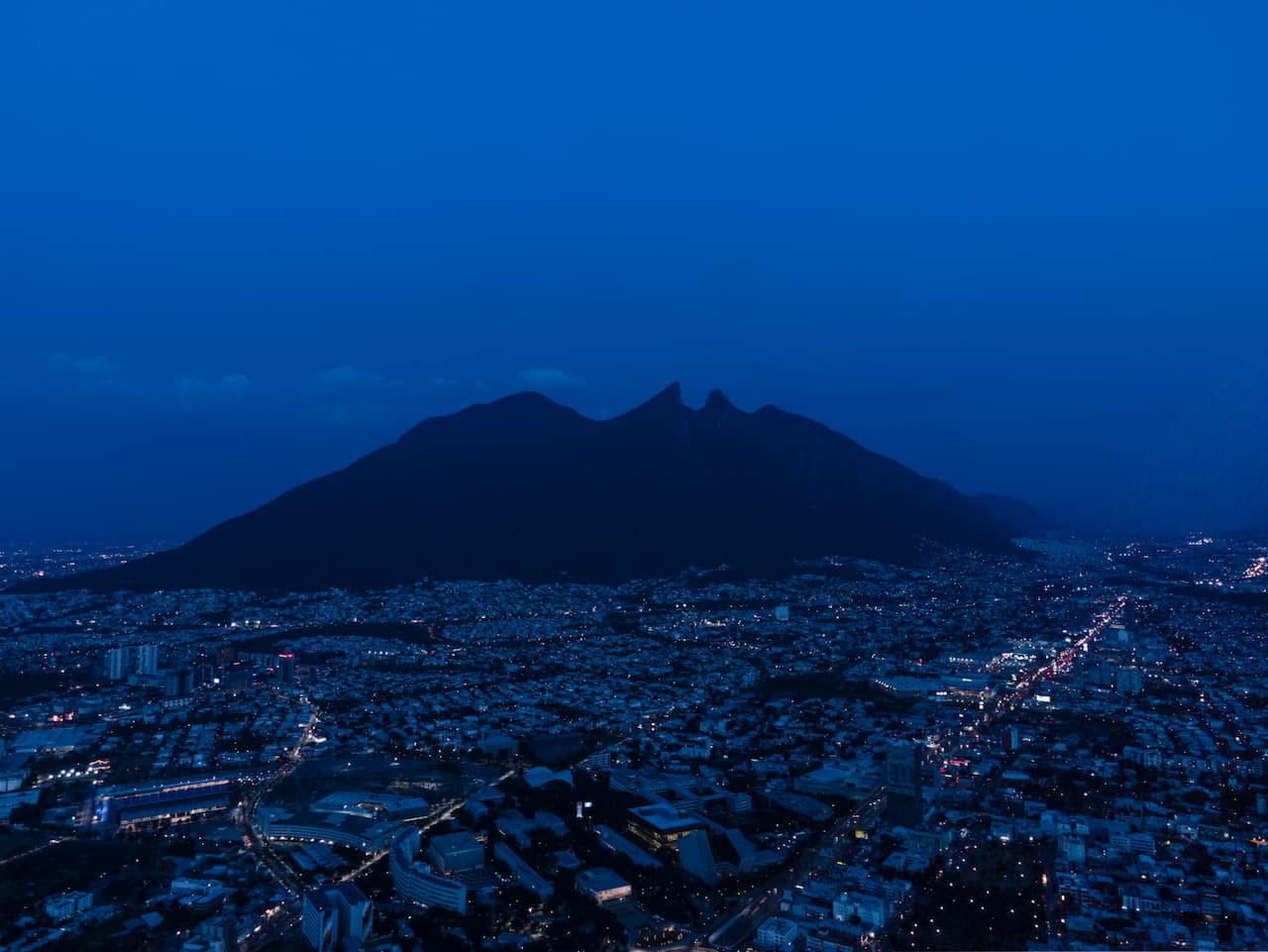 Vista nocturna del Cerro de la Silla en Monterrey, destacando la importancia de la ciudad.